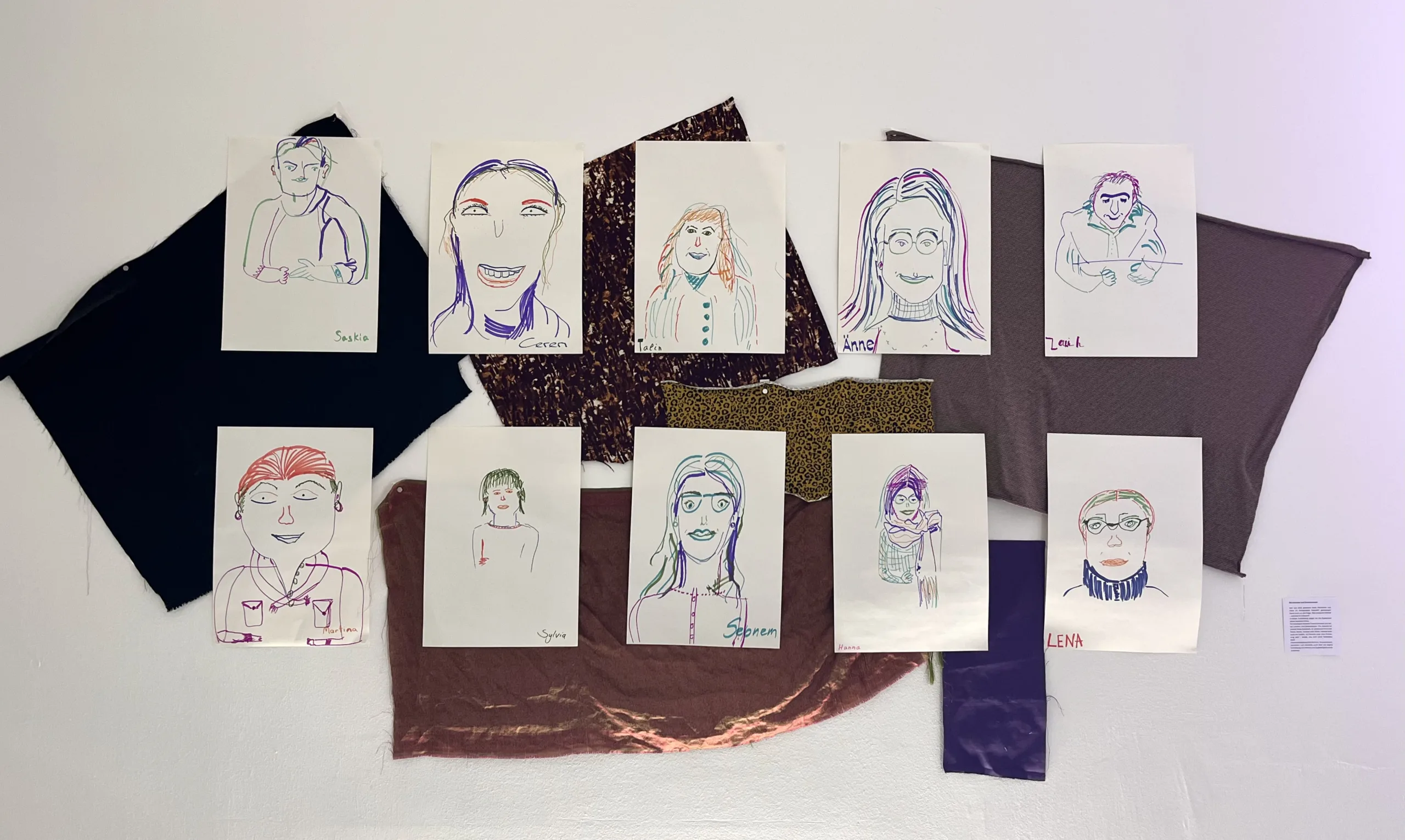Das Kunstwerk zeigt 10 Bilder. Auf jedem Papier ist mit vielen unterschiedlichen Farben eine Person gemalt. Es steht jeweils ein Name unter den Personen: Saskia, Ceren, Talin, Änne, Sarkisjan, Martina, Sylvia, Sebnem, Hanna und Lena.