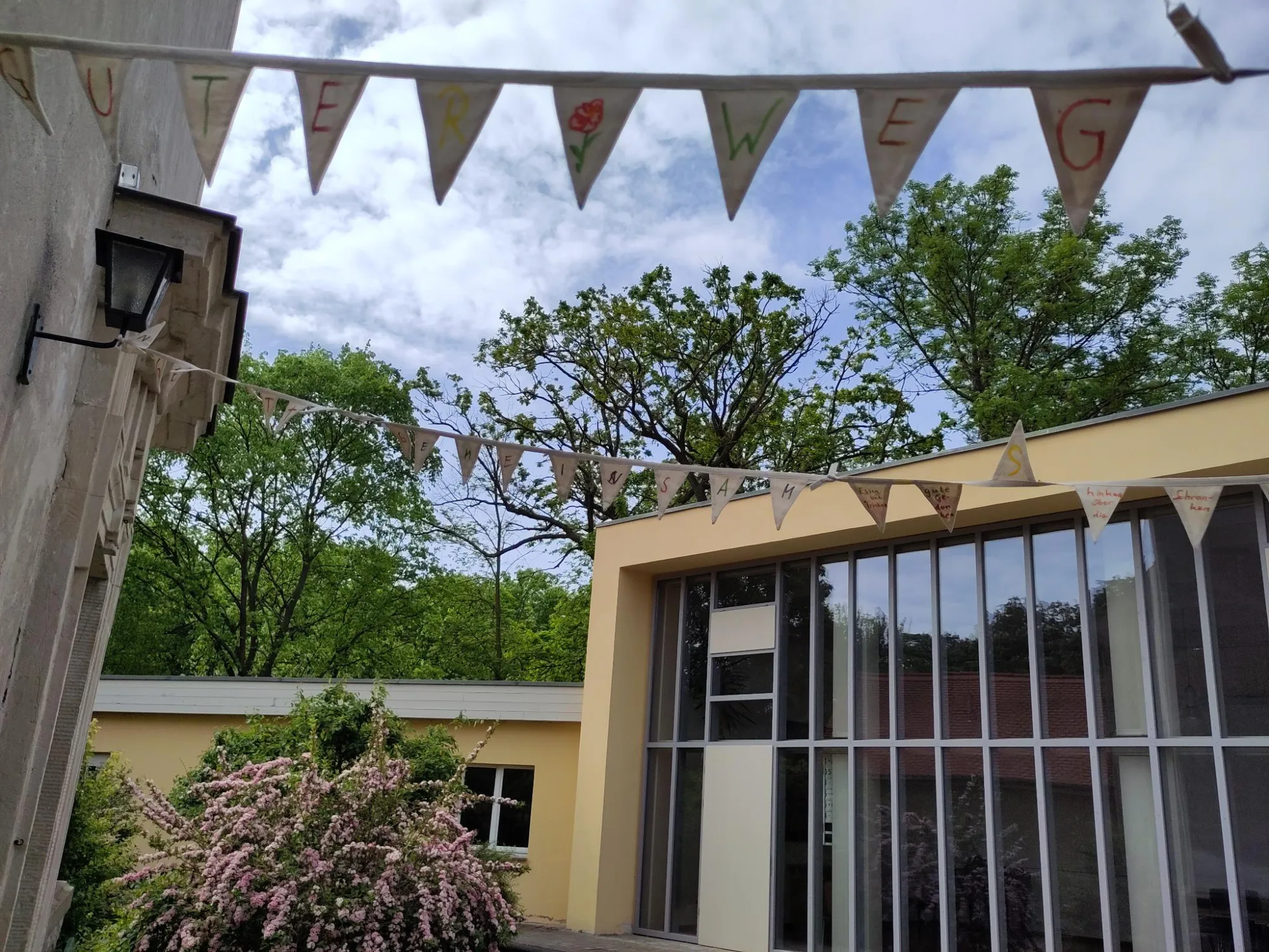 Das Gemeindezentrum mit einer Wimpelkette auf der steht: Guter Weg