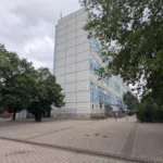 Blau-gelb gestreiftes Hochhaus am Treff in dem sich der Quartierladen befindet.